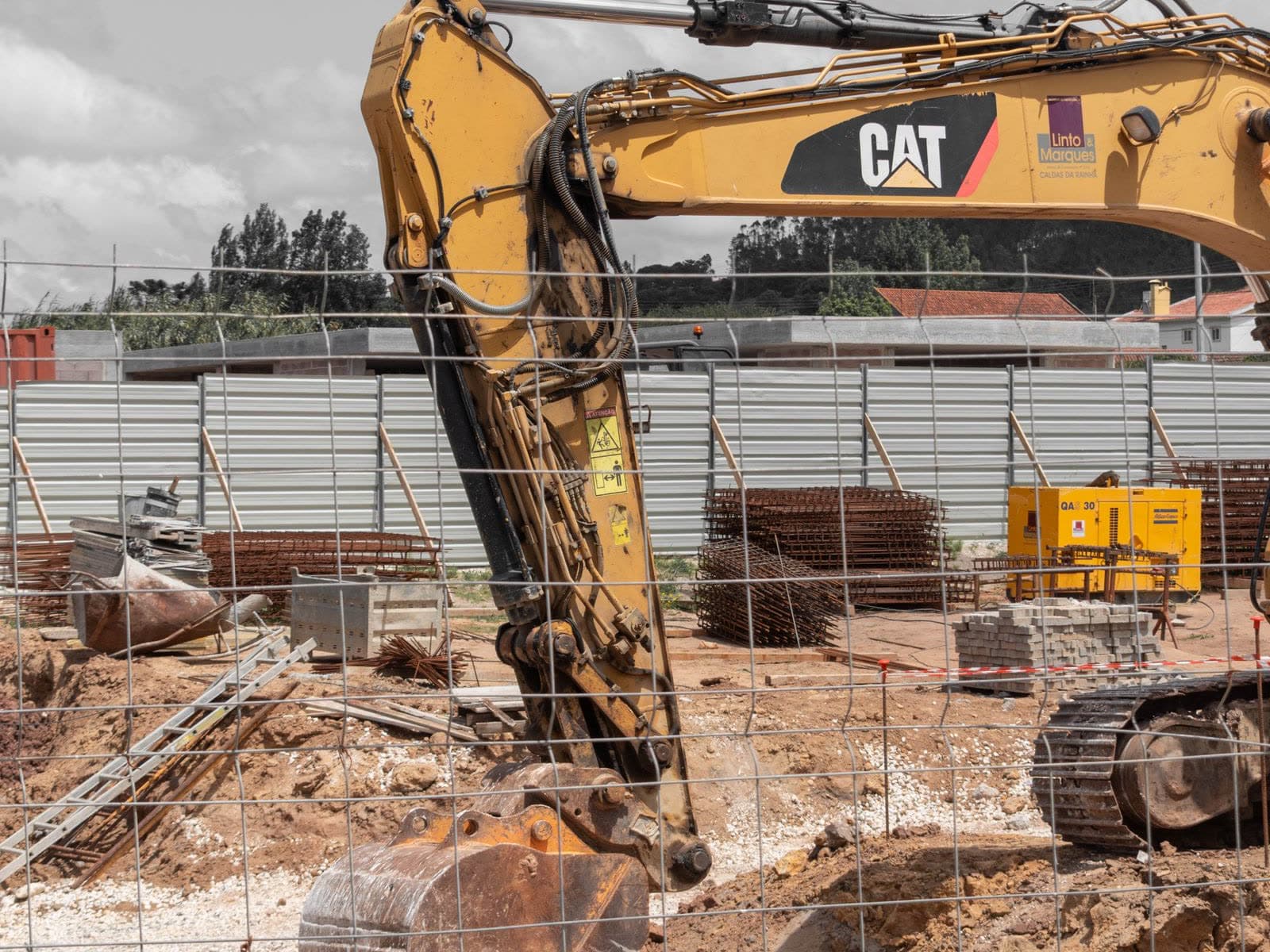 Excavadora con la cuchara dentro del hueco abierto en el terreno, en la primera fase de la obra. Imagen ilustrativa.